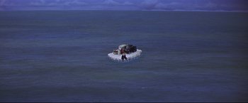 Movie still from “The Great Race” (1965), directed by Blake Edwards – A couple of people on a raft in the middle of the ocean; Extreme Wide shot, High angle