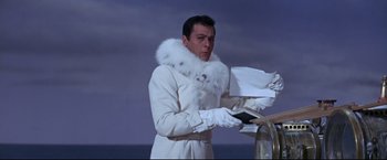 Movie still from “The Great Race” (1965), directed by Blake Edwards – A man in a white coat and white gloves holding papers; Medium shot, Low angle