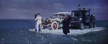 Movie still from “The Great Race” (1965), directed by Blake Edwards – A couple of people standing in front of an airplane; Wide shot, High angle