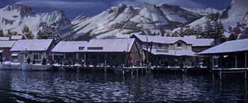 Movie still from “The Great Race” (1965), directed by Blake Edwards – A painting of a dock with a mountain in the background; Extreme Wide shot, High angle