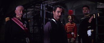 Movie still from “The Great Race” (1965), directed by Blake Edwards – A man with a mustache standing next to another man in a uniform; Medium shot, Low angle
