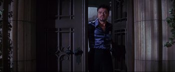 Movie still from “The Great Race” (1965), directed by Blake Edwards – A man standing in front of an open door; Medium shot, Low angle