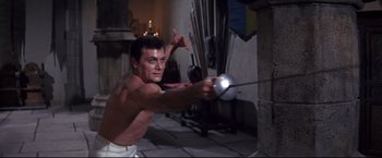 Movie still from “The Great Race” (1965), directed by Blake Edwards – A man is holding a sword in a room; Medium shot, Low angle