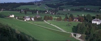 Movie still from “The Great Race” (1965), directed by Blake Edwards – An aerial view of a rural area with a car driving down the road; Extreme Wide shot, High angle