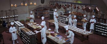 Movie still from “The Great Race” (1965), directed by Blake Edwards – A group of men in a kitchen preparing cakes; Wide shot, High angle