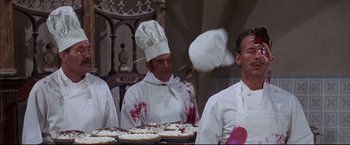 Movie still from “The Great Race” (1965), directed by Blake Edwards – A group of men standing next to each other in front of pies; Medium shot, Over the shoulder angle
