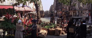 Movie still from “The Great Race” (1965), directed by Blake Edwards – A group of people standing on a sidewalk near a tree; Wide shot, High angle