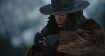 Movie still from “The Great Silence” (1968), directed by Sergio Corbucci – A man in a hat and gloves is holding a stick; Close Up shot, Low angle
