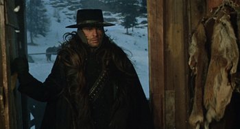 Movie still from “The Great Silence” (1968), directed by Sergio Corbucci – A man with long hair wearing a black hat; Medium shot, Low angle