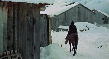 Movie still from “The Great Silence” (1968), directed by Sergio Corbucci – A man riding a horse through the snow; Wide shot, Low angle