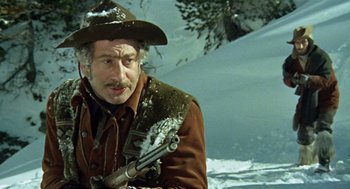 Movie still from “The Great Silence” (1968), directed by Sergio Corbucci – A man in a cowboy hat holding a gun; Close Up shot, Low angle