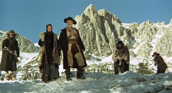 Movie still from “The Great Silence” (1968), directed by Sergio Corbucci – A group of people standing on top of a snow covered slope; Wide shot, Low angle