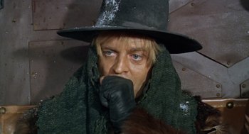 Movie still from “The Great Silence” (1968), directed by Sergio Corbucci – A man in a black hat and a green scarf; Close Up shot, Low angle