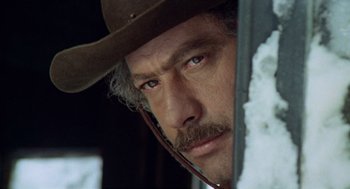 Movie still from “The Great Silence” (1968), directed by Sergio Corbucci – A person wearing a cowboy hat; Close Up shot, Low angle