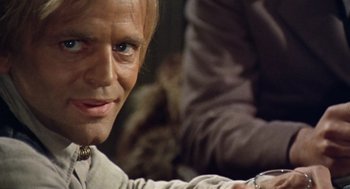 Movie still from “The Great Silence” (1968), directed by Sergio Corbucci – A person with a cat in the background; Close Up shot, Over the shoulder angle