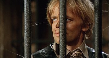 Movie still from “The Great Silence” (1968), directed by Sergio Corbucci – A person behind a metal fence; Close Up shot, Low angle