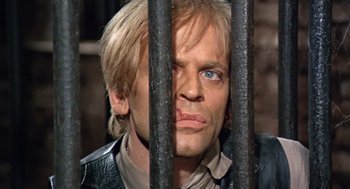 Movie still from “The Great Silence” (1968), directed by Sergio Corbucci – A person behind a metal fence; Close Up shot, Low angle