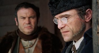 Movie still from “The Great Silence” (1968), directed by Sergio Corbucci – A man in a hat and glasses and another man in a fur coat; Close Up shot, Over the shoulder angle