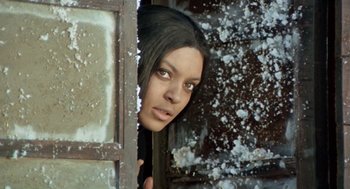 Movie still from “The Great Silence” (1968), directed by Sergio Corbucci – A woman looking out of a window with snow on the ground; Close Up shot, Low angle