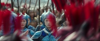 Movie still from “The Great Wall” (2016), directed by Yimou Zhang – A group of people dressed in costumes and holding red sticks; Medium shot, Over the shoulder angle