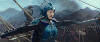 Movie still from “The Great Wall” (2016), directed by Yimou Zhang – A woman dressed as a blue knight with a bird on her shoulder; Medium shot, Over the shoulder angle