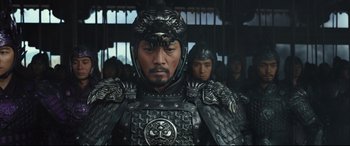 Movie still from “The Great Wall” (2016), directed by Yimou Zhang – A man in a black and silver armor stands in front of a group of men; Medium shot, Low angle