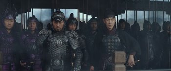 Movie still from “The Great Wall” (2016), directed by Yimou Zhang – A group of men in armor standing next to each other; Medium shot, Over the shoulder angle