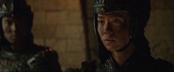 Movie still from “The Great Wall” (2016), directed by Yimou Zhang – A man wearing a helmet is looking at the camera; Close Up shot, Low angle
