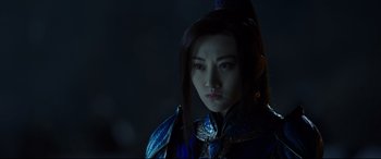 A woman with long black hair wearing a blue outfit