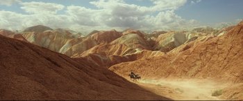 Movie still from “The Great Wall” (2016), directed by Yimou Zhang – A man riding a horse down a dirt road; Extreme Wide shot, High angle
