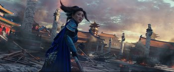Movie still from “The Great Wall” (2016), directed by Yimou Zhang – A woman in a blue dress holding a sword in front of a building; Medium shot, Low angle