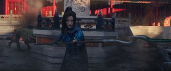 Movie still from “The Great Wall” (2016), directed by Yimou Zhang – A woman holding a sword in front of a building; Medium shot, Over the shoulder angle