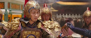 Movie still from “The Great Wall” (2016), directed by Yimou Zhang – Two men dressed in gold and blue are standing in front of a crowd; Close Up shot, Over the shoulder angle