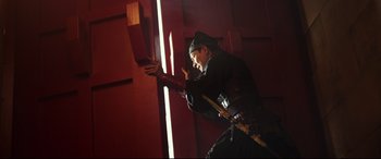 Movie still from “The Great Wall” (2016), directed by Yimou Zhang – A man holding a sword in a dark room; Medium shot, Low angle