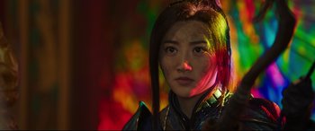 Movie still from “The Great Wall” (2016), directed by Yimou Zhang – A young woman with long black hair wearing a blue and red outfit; Close Up shot, Over the shoulder angle