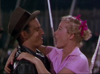 Movie still from “The Greatest Show on Earth” (1952), directed by Cecil B. DeMille – A man and a woman embracing each other in front of a string; Medium shot, Low angle