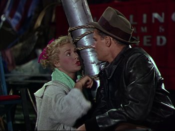 Movie still from “The Greatest Show on Earth” (1952), directed by Cecil B. DeMille – A man and a woman are kissing on the street; Medium shot, High angle