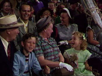 Movie still from “The Greatest Show on Earth” (1952), directed by Cecil B. DeMille – A group of people sitting and standing in a room; Medium shot, High angle