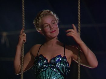 Movie still from “The Greatest Show on Earth” (1952), directed by Cecil B. DeMille – A woman in a blue and black dress on a rope swing; Medium shot, Low angle