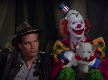 Movie still from “The Greatest Show on Earth” (1952), directed by Cecil B. DeMille – A man and a clown holding a dog; Medium shot, Low angle
