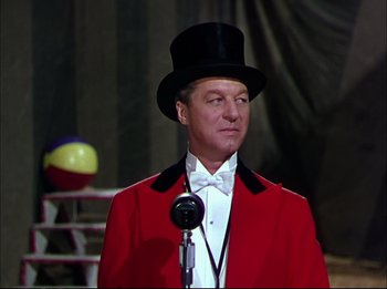 Movie still from “The Greatest Show on Earth” (1952), directed by Cecil B. DeMille – A man wearing a red jacket and a black hat; Medium shot, Over the shoulder angle