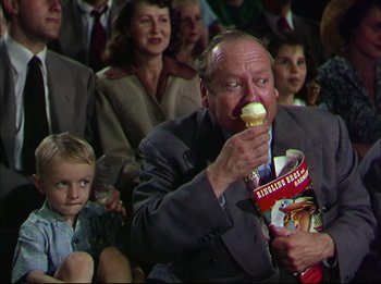 Movie still from “The Greatest Show on Earth” (1952), directed by Cecil B. DeMille – An older man eating a sandwich in front of an audience; Medium shot, High angle