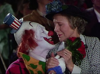 Movie still from “The Greatest Show on Earth” (1952), directed by Cecil B. DeMille – An older woman holding a clown's hand and a rose; Close Up shot, High angle