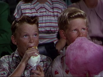 Movie still from “The Greatest Show on Earth” (1952), directed by Cecil B. DeMille – Two young boys are eating cotton candy while watching a movie; Medium shot, High angle
