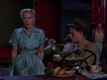 Movie still from “The Greatest Show on Earth” (1952), directed by Cecil B. DeMille – A man and a woman sitting at a dining table; Medium shot, Over the shoulder angle