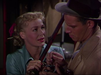 Movie still from “The Greatest Show on Earth” (1952), directed by Cecil B. DeMille – A man and a woman holding a baseball bat together; Close Up shot, Over the shoulder angle