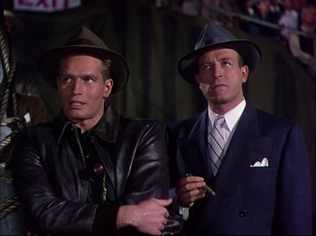 Movie still from “The Greatest Show on Earth” (1952), directed by Cecil B. DeMille – A couple of men standing next to each other in a room; Medium shot, Low angle