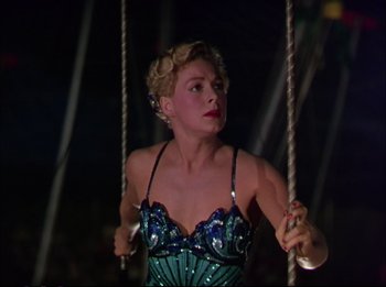 Movie still from “The Greatest Show on Earth” (1952), directed by Cecil B. DeMille – A woman in a blue dress is on a swing; Medium shot, Low angle