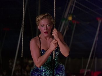 Movie still from “The Greatest Show on Earth” (1952), directed by Cecil B. DeMille – A woman in a blue dress on top of a rope swing; Medium shot, Low angle
