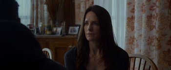 Movie still from “The Guest” (2014), directed by Adam Wingard – A person sitting in a room near a window; Close Up shot, Over the shoulder angle